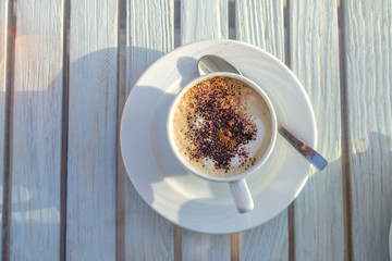 Wall Mural - cup of cappuccino with latte art on wooden white table. top view