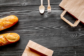 Wall Mural - bread in paper bag on wooden background