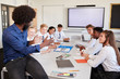 © Monkey Business - Male High School Teacher Sitting At Table With Teenage Pupils Wearing Uniform Teaching Lesson