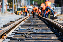 Workers In Bright Uniforms Lay Railway Or Tram Tracks