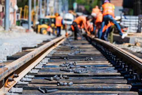 Fotografía Workers in bright uniforms lay railway or tram tracks