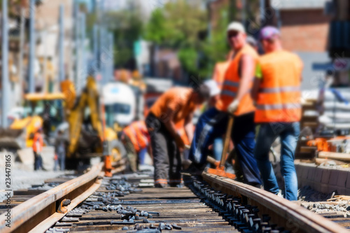 Cuadros en Lienzo Workers in bright uniforms lay railway or tram tracks