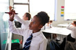 © Monkey Business - Female High School Students Wearing Uniform Using Interactive Whiteboard During Lesson