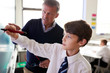 © Monkey Business - High School Teacher With Male Student Wearing Uniform Using Interactive Whiteboard During Lesson