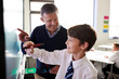 © Monkey Business - High School Teacher With Male Student Wearing Uniform Using Interactive Whiteboard During Lesson