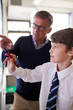 © Monkey Business - High School Teacher With Male Student Wearing Uniform Using Interactive Whiteboard During Lesson