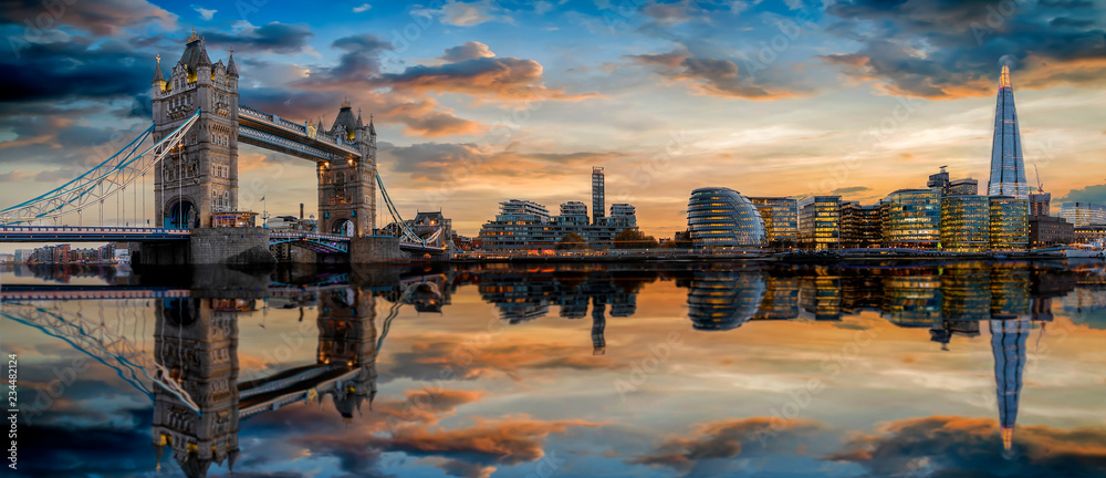 Die Skyline von London: von der Tower Bridge bis zum Tower nach Sonnenuntergang mit Reflektionen in der Themse - obrazy, fototapety, plakaty 