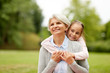 © Syda Productions - family, leisure and people concept - happy granddaughter hugging her grandmother at summer park