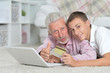 © aletia2011 - Grandfather and grandson lying on floor and using laptop, grands
