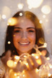 portrait of pretty woman with warm string lights festive holidays