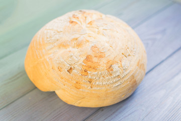 Wall Mural - Round white bread on color wooden background.