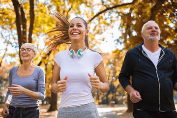 Senior man and woman and young female instructor  workout on fresh air. Outdoor activities, healthy lifestyle, strong bodies, fit figures.