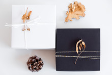 Luxury New Year Gift With Gold Leaves Decoration. Christmas Background With Gift Box. Presents For Christmastime Celebration.