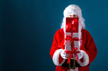 Santa Holding Christmas Gift Boxes On A Dark Blue Background