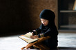 © Asada - Asian Indonesian Muslim kid is reading the Quran. The Quran is indicated as the guided book for all Muslim and it is direction  to be on the heaven of God.Mosque,Islam,religion and knowledge concept.