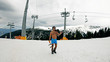 Sexy naked gay holding skies pose on ski slope under ski lift smiling