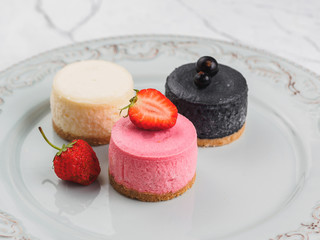 Wall Mural - Round mini cheesecake. Classic, strawberry and currant