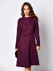 Young beautiful woman posing in new dark purple fashion winter dress 