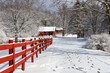 Beautiful winter nature background. Rural landscape with red barns, wooden red fence and trees covered by fresh snow in sunlight. Scenic winter view at Wisconsin, Midwest USA, Madison area.