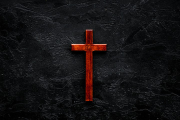funeral concept. wooden cross on black background top view copy space