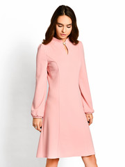 Young beautiful woman posing in new pink   fashion winter dress on a white 