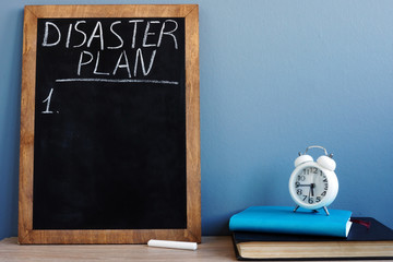 Wall Mural - Disaster Plan written on a blackboard and notepads.