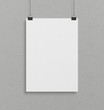 © sdecoret - Blank white poster hanging up with clips mockup