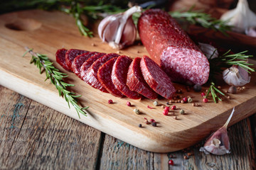 Wall Mural - Smoked salami on a old wooden table.