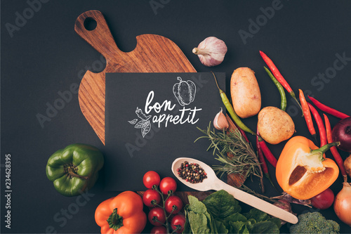 Plakaty do jadalni top-view-of-black-board-on-wooden-table-with-vegetables-on-gray-table-bon-appetit-lettering