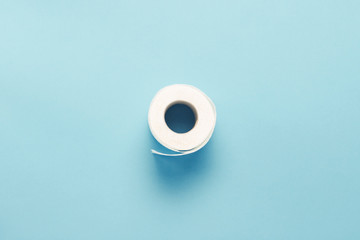 Roll of toilet paper on a blue background. Flat lay, top view