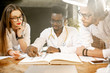 © rh2010 - Group of a young multi ethnicity physicians or medical students in uniform working with book and drawings on the table in the office or classroom