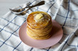 © Liudmyla - Stack of homemade pancakes with butter on pink plate, side view. Close-up.