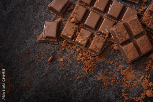 Fotomural chocolate and cocoa powder on a dark slate background with copy space, high angl