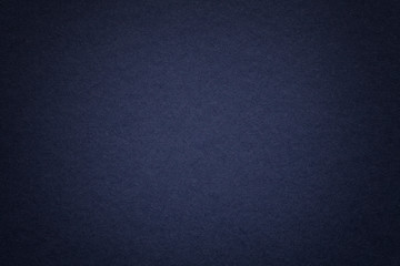 Texture of old navy blue paper background, closeup. Structure of dense cardboard.