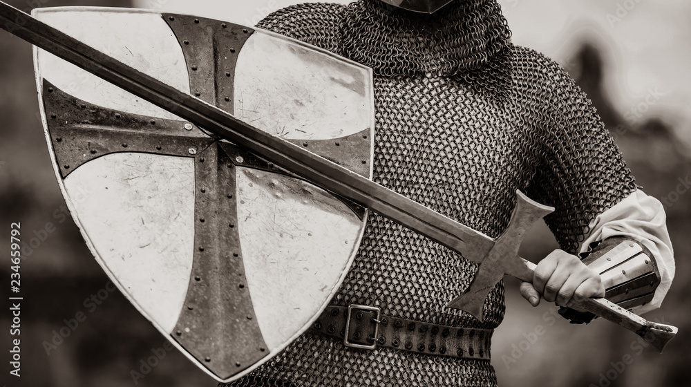 Closeup view on traditional medieval knight with shield and sword. Image in black and white color style - obrazy, fototapety, plakaty 