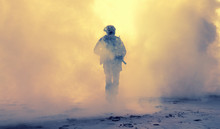 Special Operations Forces Soldier, Army Ranger Or Commando In Camo Uniform, Helmet And Ballistic Glasses Walking At Battlefield Covered With Smoke. Airsoft War Game Player Coming Through Smoke Screen