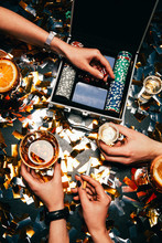 Partial View Of Friends Celebrating With Alcohol, Cigarettes And Playing Cards At Table Covered By Golden Confetti