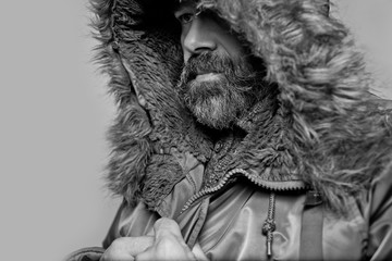 Wall Mural - Handsome man with a beard in parka hood