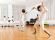 © JackF - Adults and teens wearing fencing uniform practicing with foil