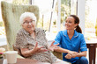 © Monkey Business - Senior Woman Sitting In Chair And Talking With Nurse In Retirement Home