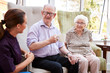© Monkey Business - Male And Female Residents Sitting In Chair And Talking With Carer In Retirement Home