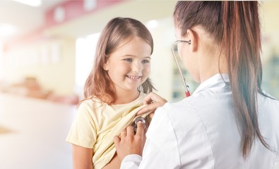 Wall Mural - Young  doctors with little girl on  background