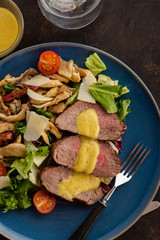 Wall Mural - Salad with warm beef with oyster mushrooms, tomatoes and greens. Top view