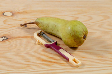 Wall Mural - Single pear beside knife on wooden table