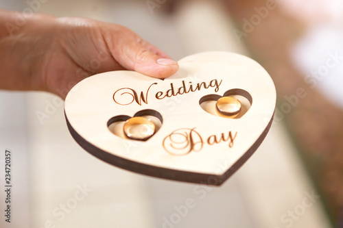 Fotografía newlyweds wedding rings on a wooden heart-shaped stand in the church