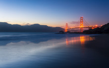 Soft Flowing Water Reflects The Beautiful Golden Gate Bridge From Baker Beach, San Francisco, California