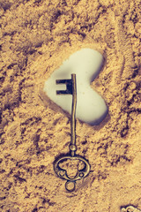 Wall Mural - Retro style key and a heart shape on brown sand