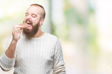 Sticker - Young hipster man eating chocolate bar over isolated background with a confident expression on smart face thinking serious