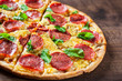 © pavel siamionov - Pepperoni Pizza with Mozzarella cheese, salami, Tomato sauce, pepper, Spices and Fresh Basil. Italian pizza on wooden table background