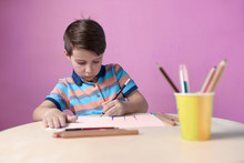 European Boy Carefully Drawing With Colorful Pencils.
